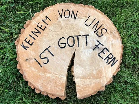 Baumscheibe mit Spruch-Keinem von uns ist Gott fern